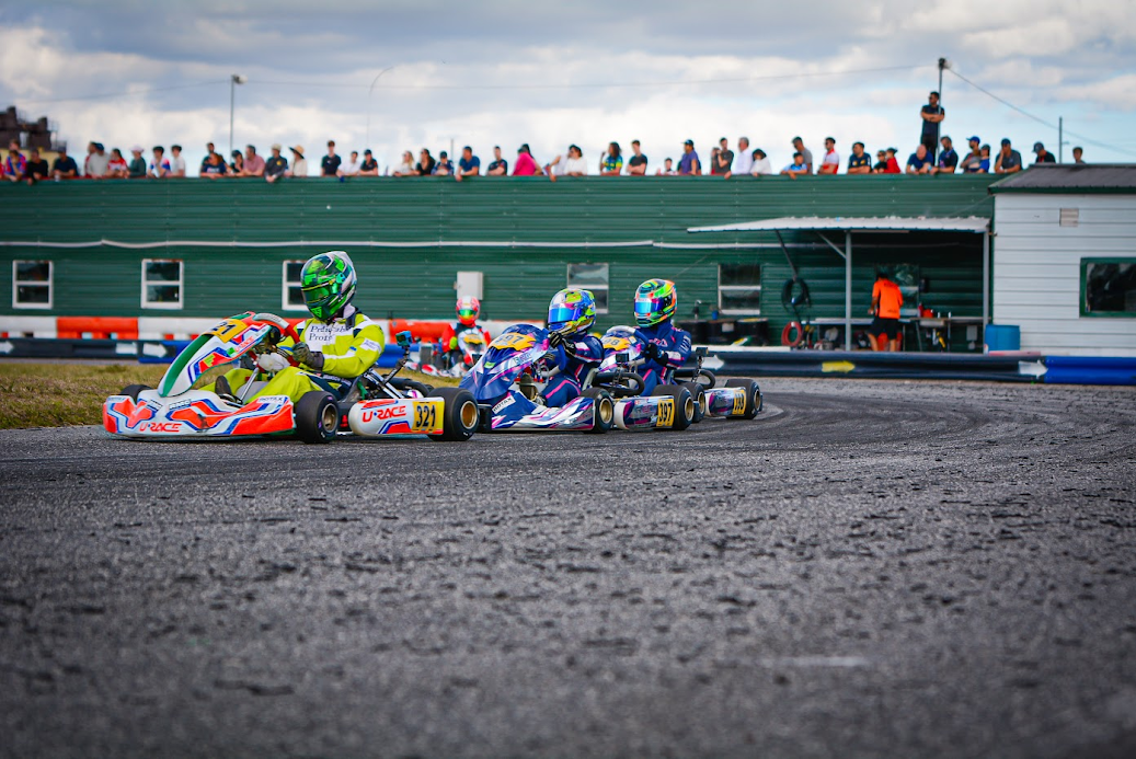 Urace kart drivers racing together on track